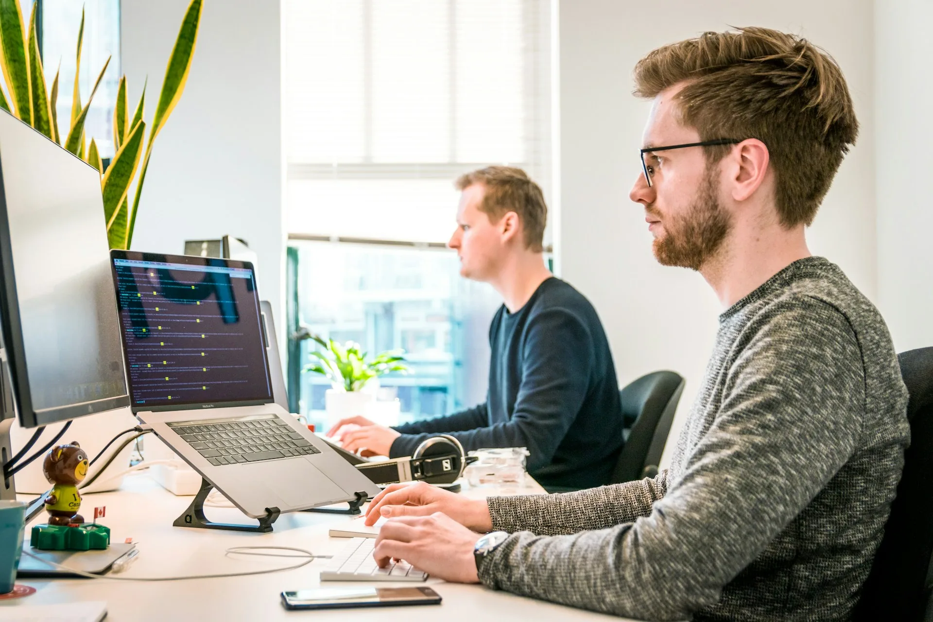 Team members working on laptops in a bright office